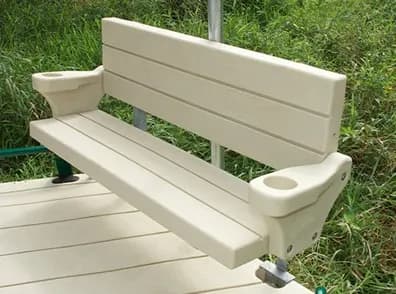 Beige polyethylene bench with armrests mounted on an EZ Dock deck, bank behind