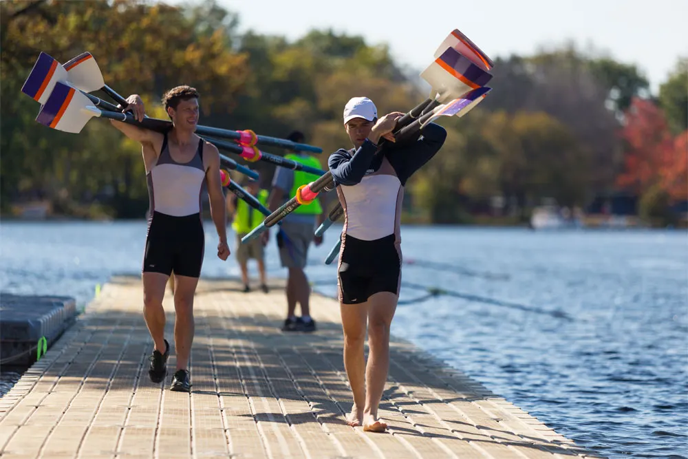 Two people walking a plain EZ Dock floating walkway on a bright autumn day