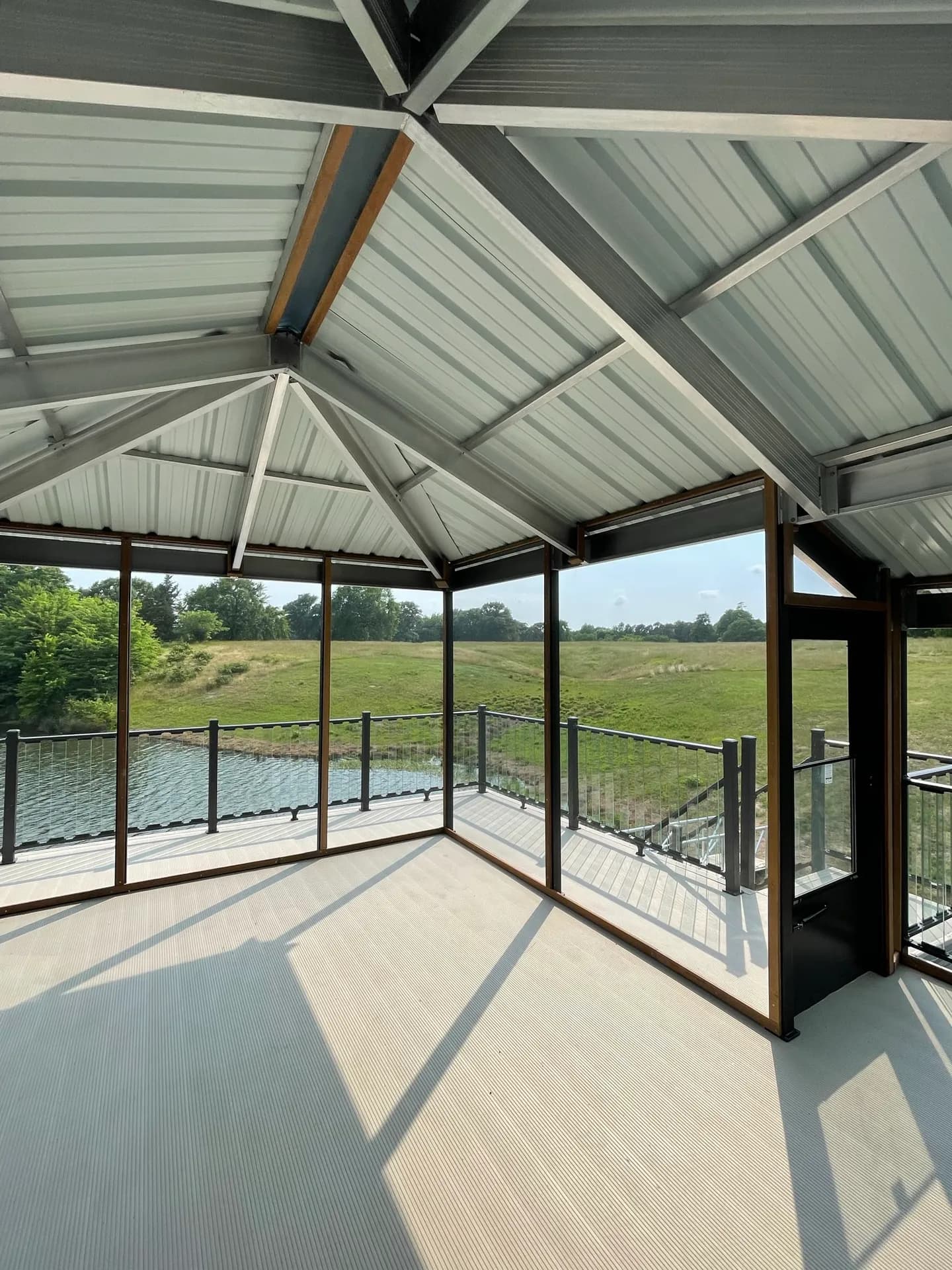 The open upper sun deck of a covered dock, railed on all sides with a clear view over the lake.