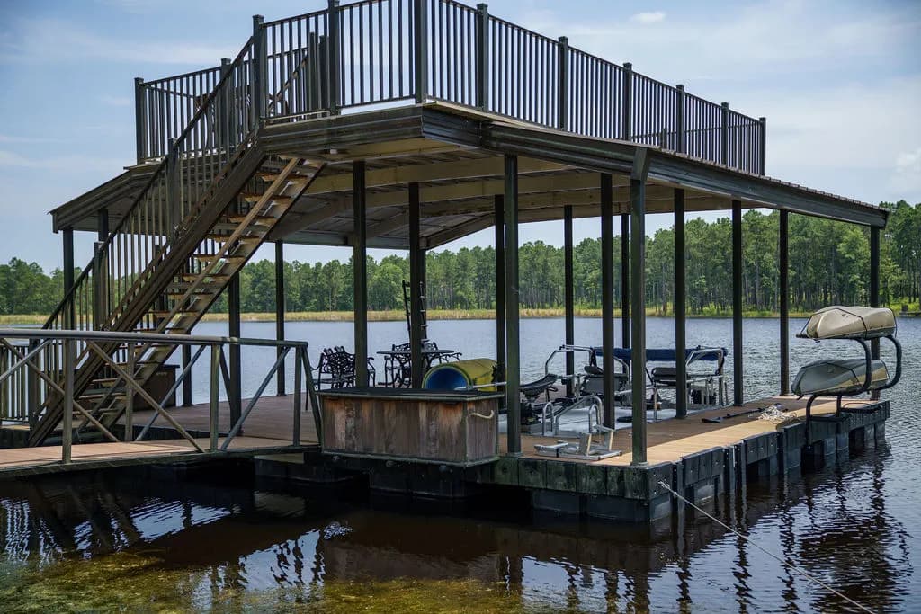 Two-story covered aluminum dock with a full upper deck and boat slips below.