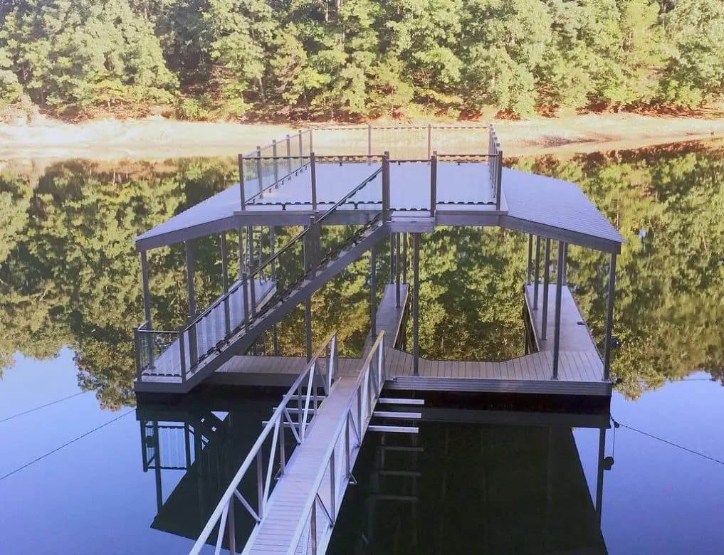 Arched gangway connecting shore to a two-story aluminum dock with upper sun deck